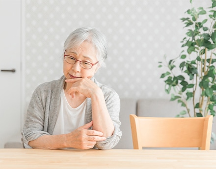 物忘れや将来への不安を感じる高齢女性、認知症の相談を表現